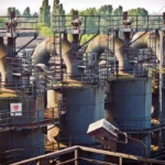 Planta industrial con torres y tuberías que requieren un plan de mantenimiento