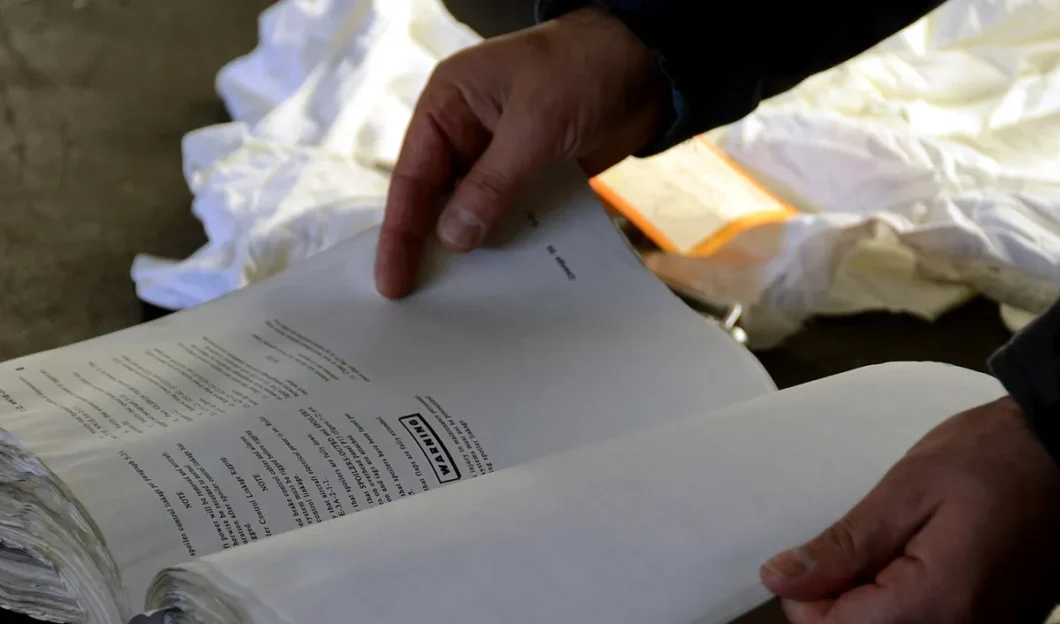 Manos revisando el manual y la lista de verificación de mantenimiento de un equipo