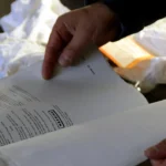 Manos revisando el manual y la lista de verificación de mantenimiento de un equipo
